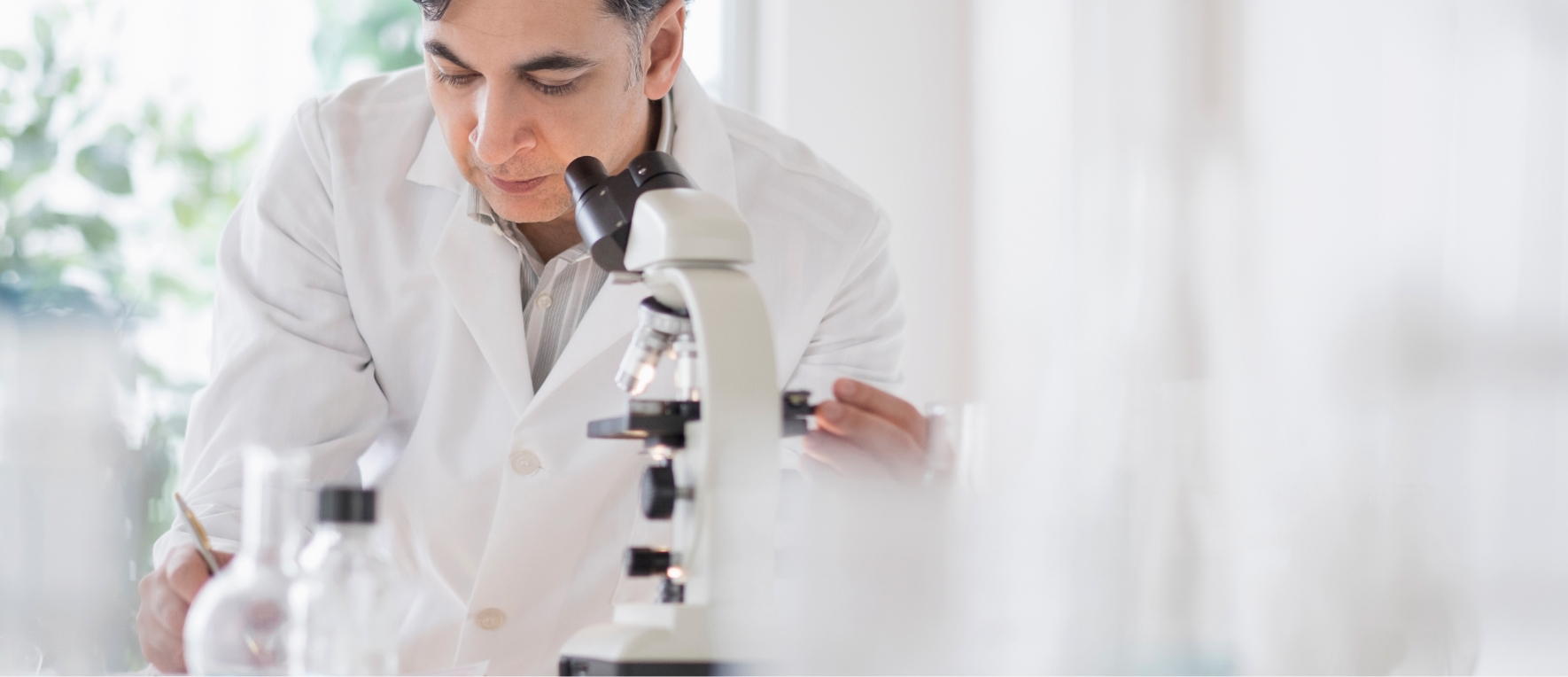 Mann hinter Mikroskop